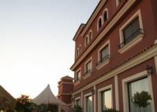 Un gran edificio rojo con muchas ventanas y una tienda de campaña al fondo.