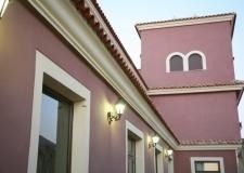 Un edificio rosa con una letra m blanca en el costado.