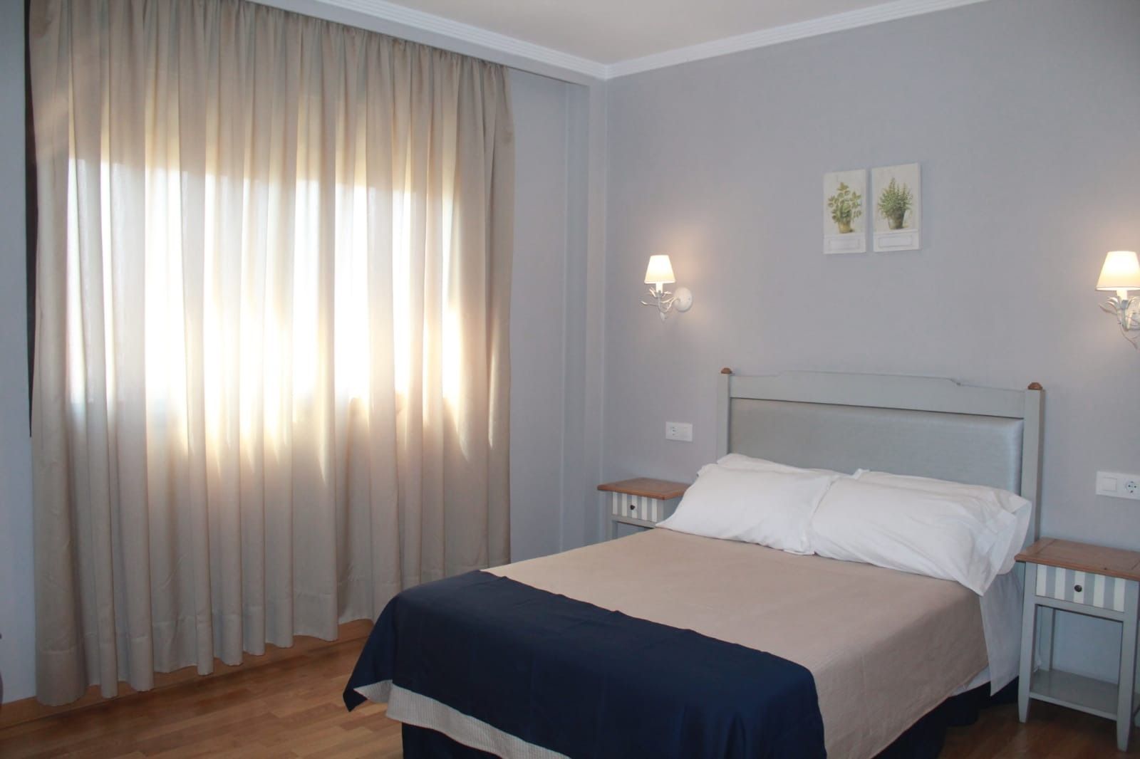 Un dormitorio con una cama y una ventana con cortinas.