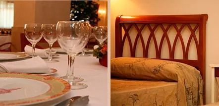 Una mesa con platos y copas de vino y una cama con cabecero de madera.