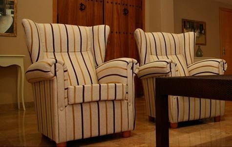 Dos sillas rayadas están una al lado de la otra en una sala de estar.