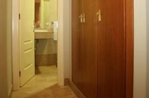 Un pasillo que conduce a un baño con lavabo y espejo.