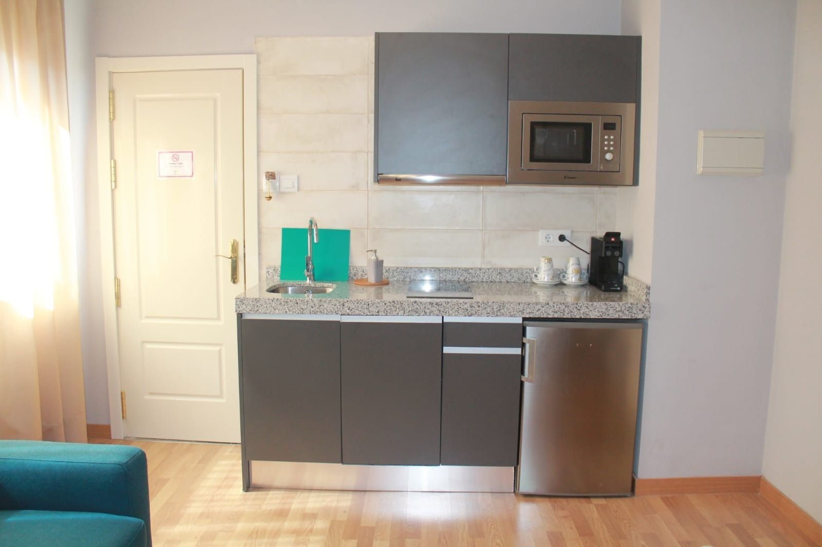 Una cocina con fregadero, microondas y lavavajillas