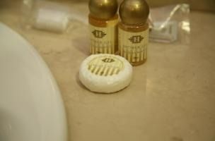 Dos botellas de champú y una pastilla de jabón están en el mostrador del baño.