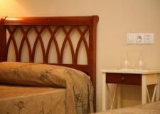 Una cama con cabecero de madera y una mesita de noche en un dormitorio.