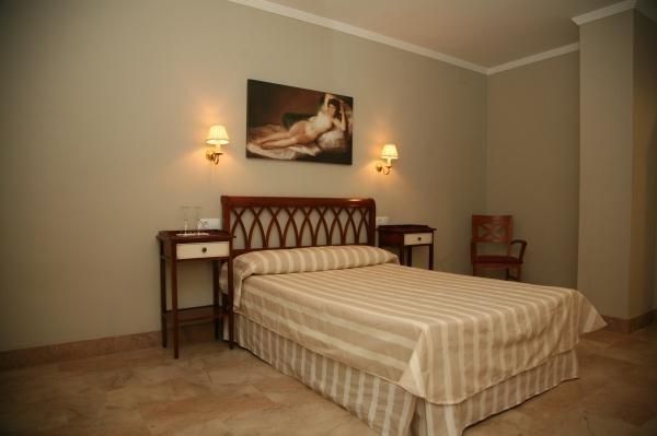 Un dormitorio con una cama y un cuadro en la pared.