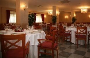 Un gran comedor con mesas y sillas preparadas para comer.