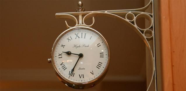 Un reloj con números romanos está colgado en una pared.