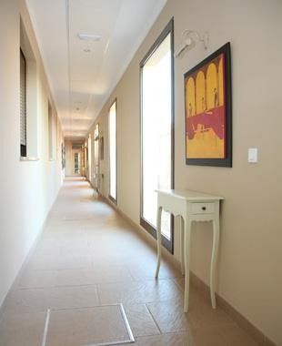 Un largo pasillo con una mesa y un cuadro en la pared.