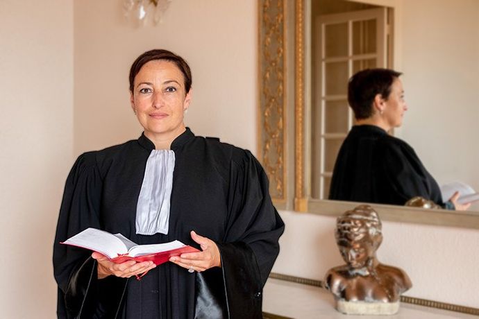 Maître Loréa CHIPI en robe d'avocat, tenant le Code civil