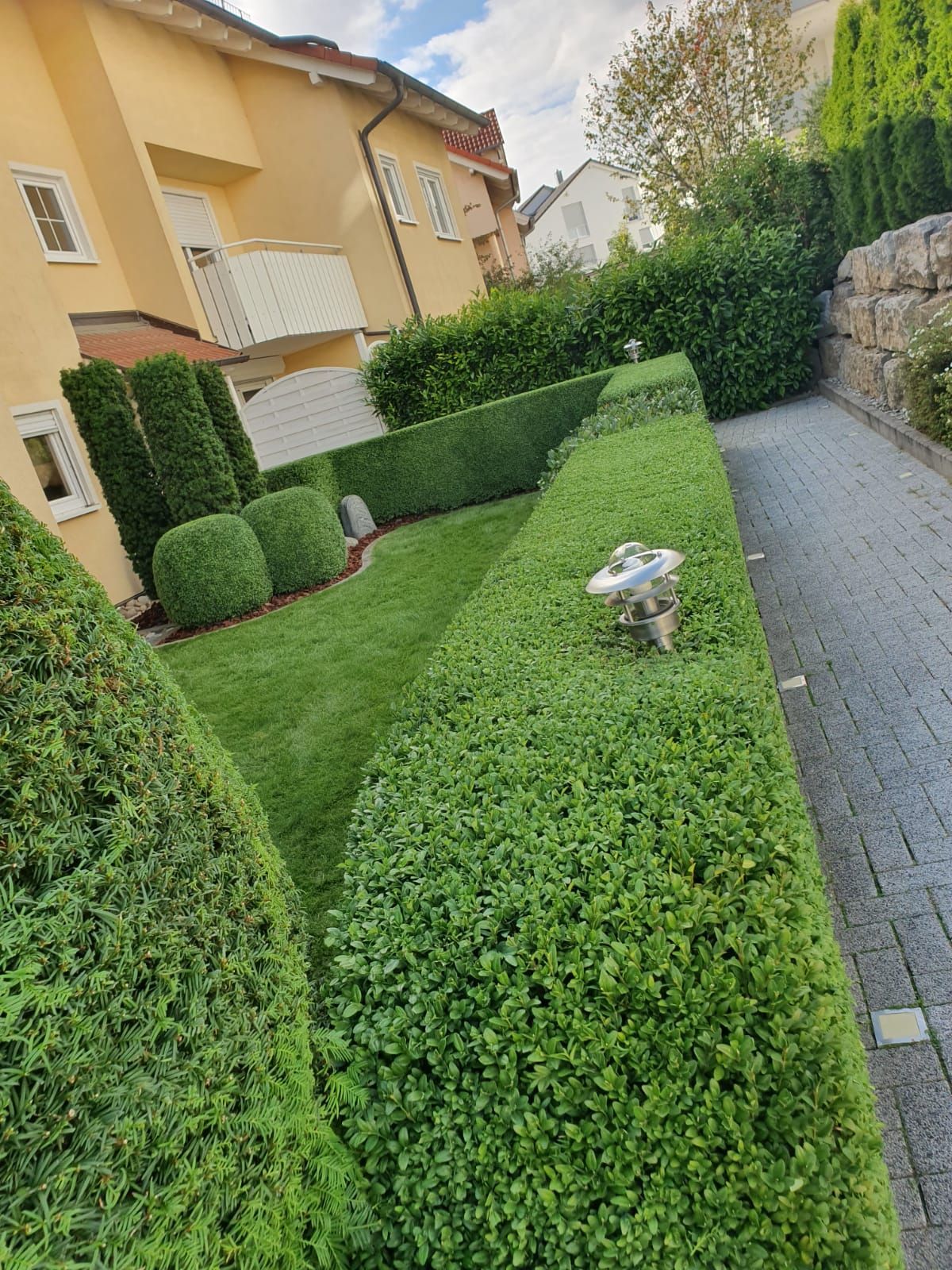 Ein Haus mit einem Balkon und einem Garten