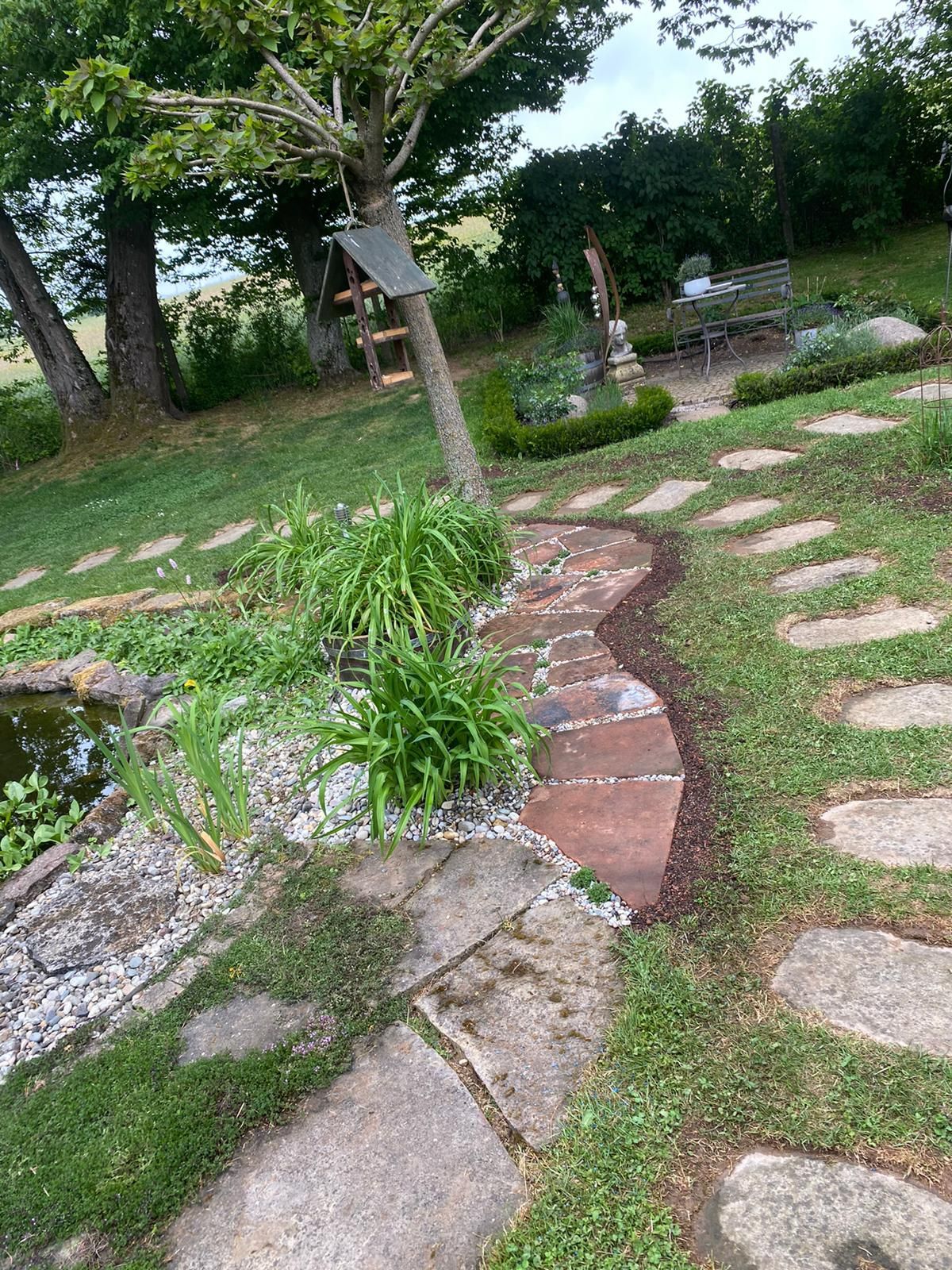 ein Garten mit Steinen und einem Teich