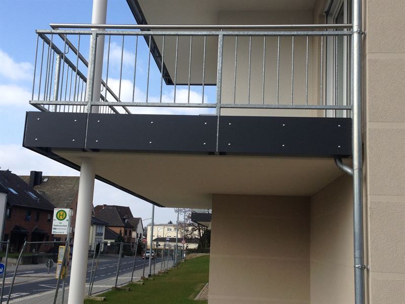 Ein Balkon mit einem Metallgeländer an der Seite eines Gebäudes