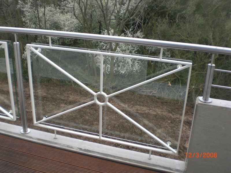 Ein Balkon mit Glasgeländer und Bäumen im Hintergrund