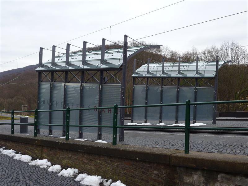 Ein grüner Zaun umgibt ein Gebäude am Straßenrand