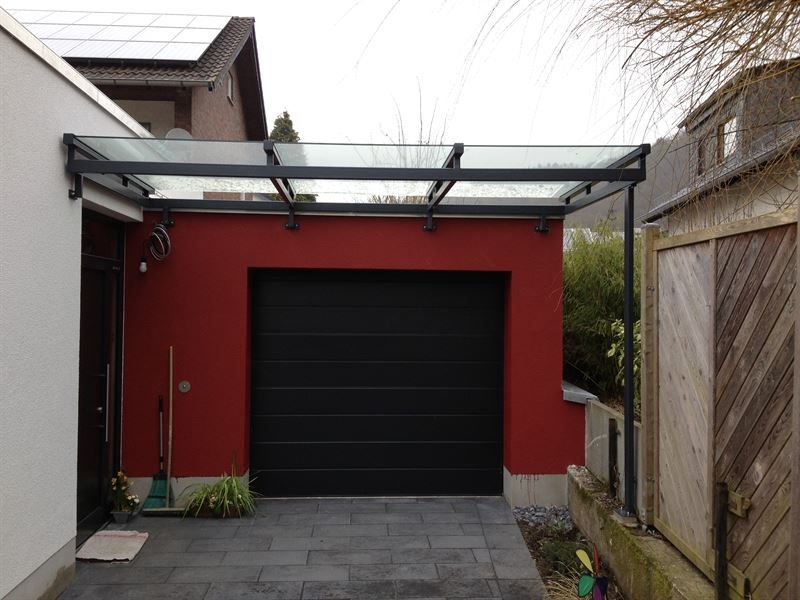 Ein schwarzes Garagentor mit einem Glasdach darüber