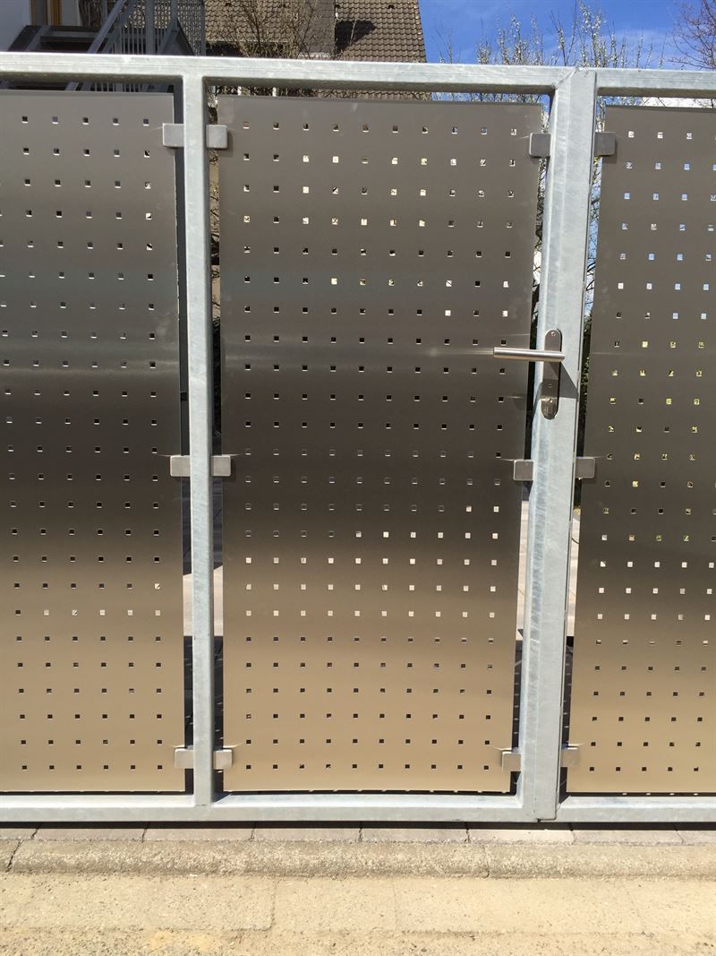 Ein Edelstahlzaun mit Löchern und einem Tor.