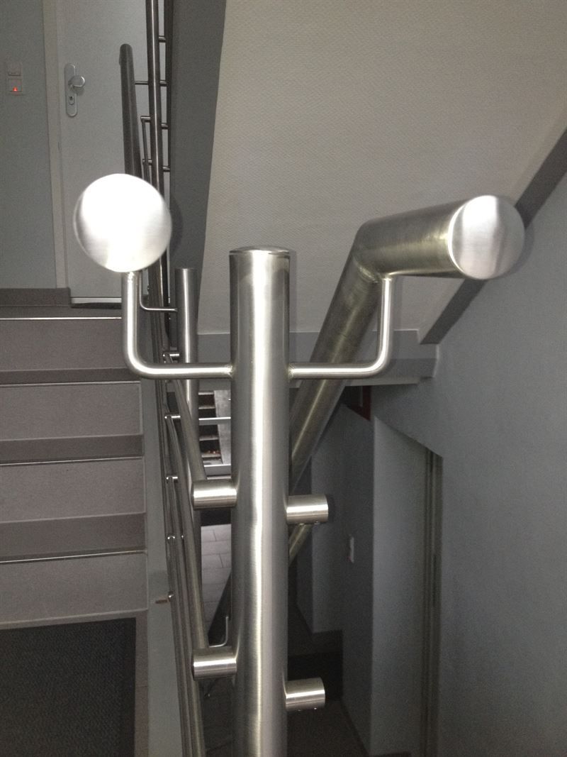 Eine Treppe mit Edelstahlgeländer und Handläufen