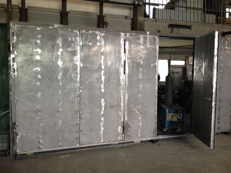 In einem Fabrikraum steht eine große Metallkiste.