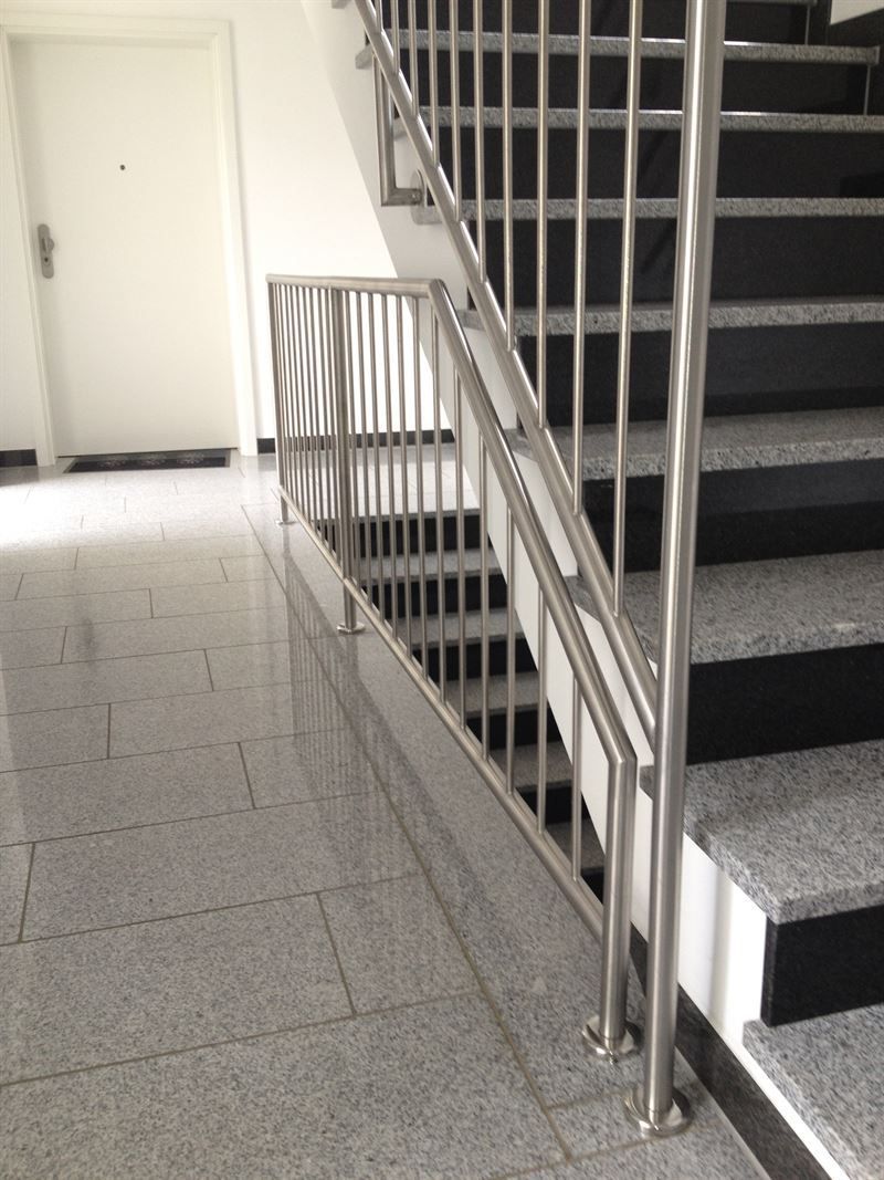 Ein Flur mit Treppe und Edelstahlgeländer
