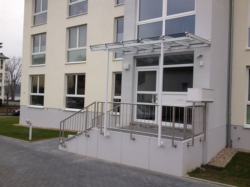 Ein weißes Gebäude mit einem Glasdach und Treppen