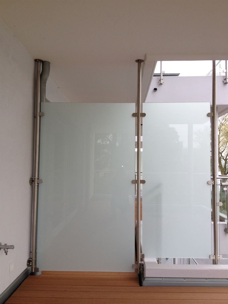 Ein leerer Raum mit einem Edelstahlgeländer und einer Glaswand
