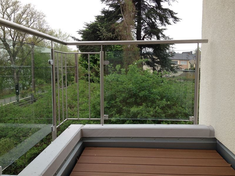 Ein Balkon mit Edelstahlgeländer und Holzboden