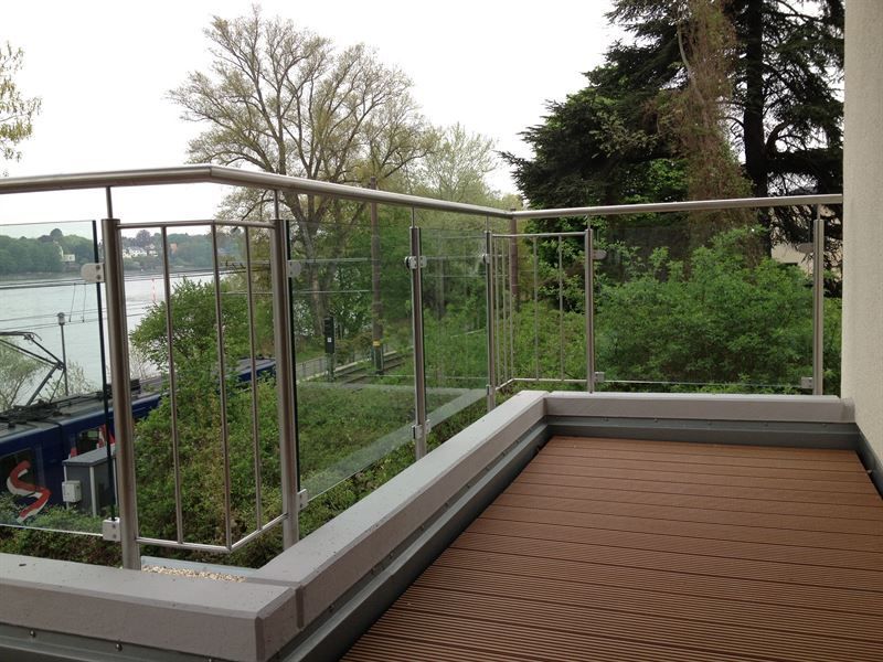 Ein Balkon mit Blick auf Bäume und ein Gewässer