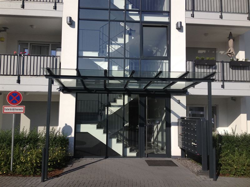 Ein Gebäude mit einem Glasdach über dem Eingang