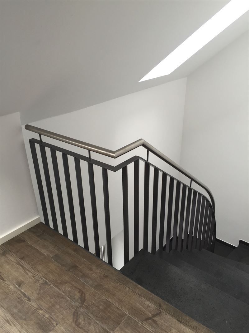 Eine Treppe mit Geländer und Holzboden