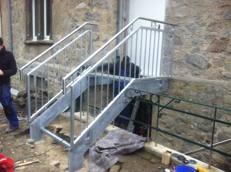 Ein Mann steht neben einer Metalltreppe