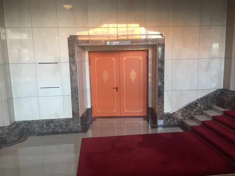 Ein Eingang in einem Gebäude mit Treppen und einem roten Teppich