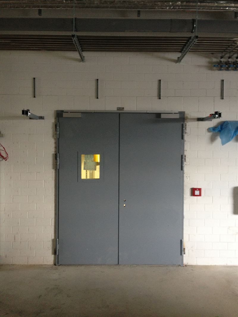 Ein leerer Raum mit einer Tür und einem Feueralarm an der Wand