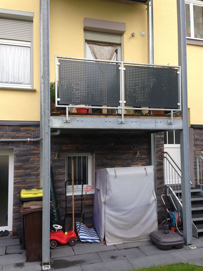 Ein gelbes Gebäude mit Balkon und Treppe