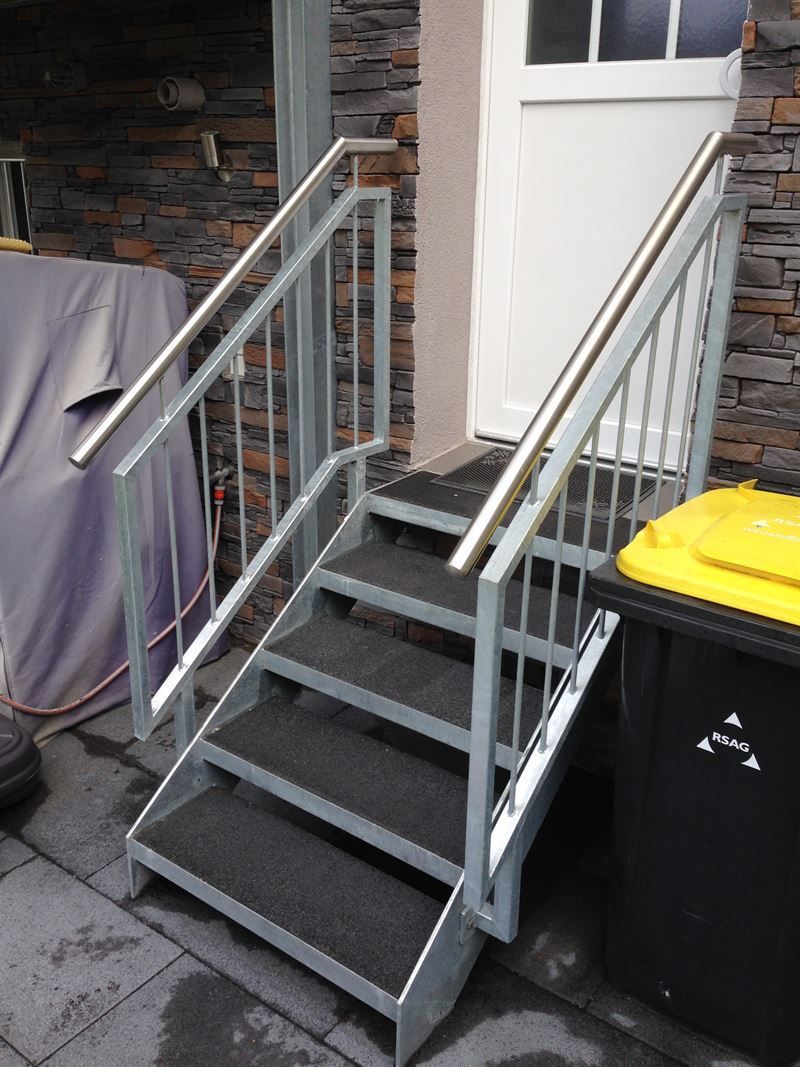 Eine Treppe, die zu einer Tür neben einem Mülleimer führt