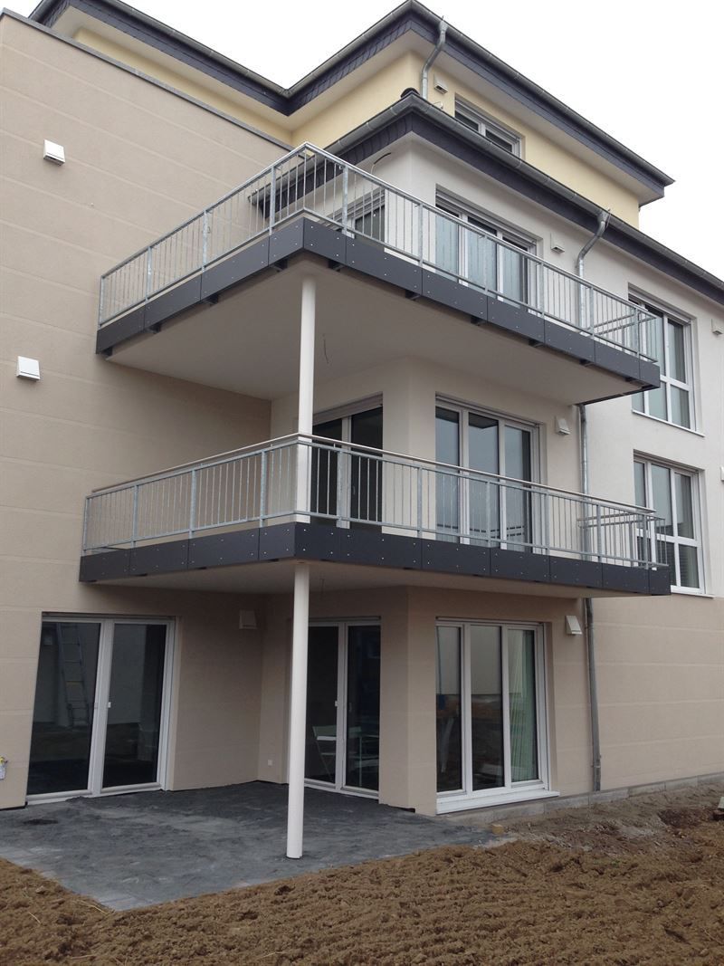 Ein großes Gebäude mit Balkon und vielen Fenstern