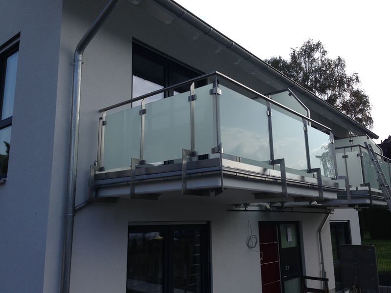 Ein Balkon an der Seite eines Hauses mit einem Edelstahlgeländer