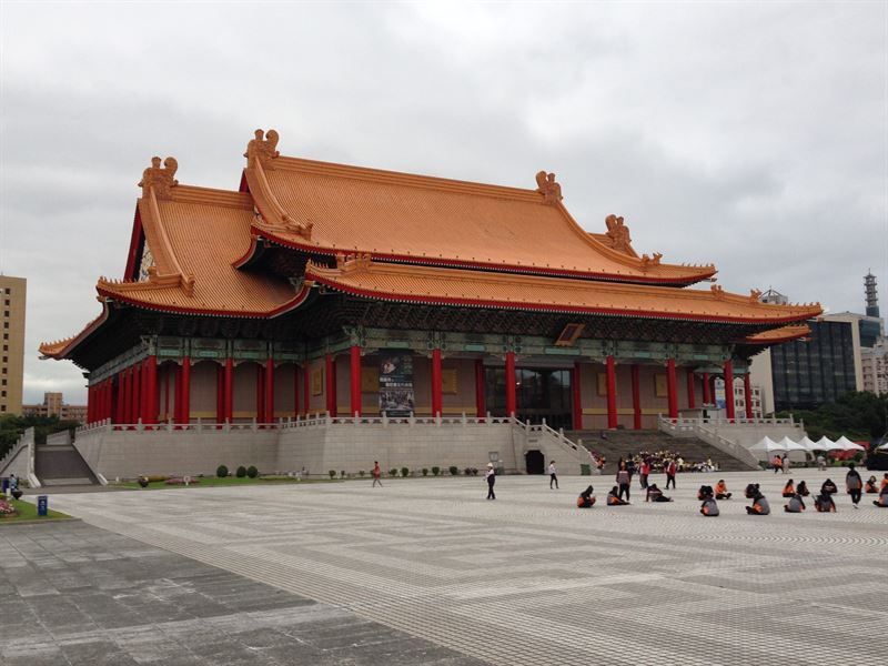 Eine Gruppe von Menschen sitzt vor einem großen Gebäude