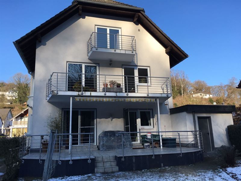 Ein großes weißes Haus mit einem Balkon im zweiten Stock