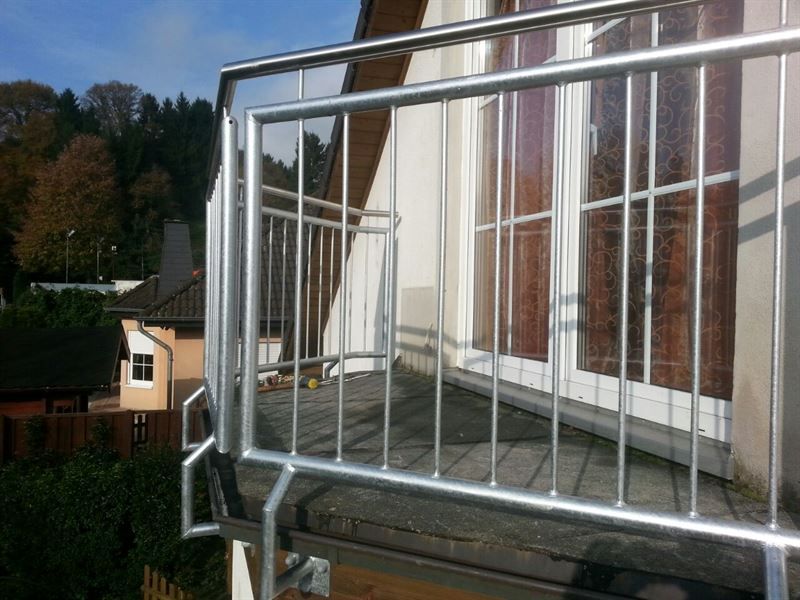 Ein Balkon mit Edelstahlgeländer und Treppe