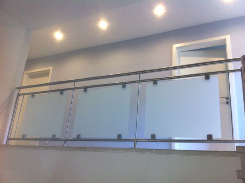 Eine Treppe mit einem Glasgeländer und einer Tür im Hintergrund.