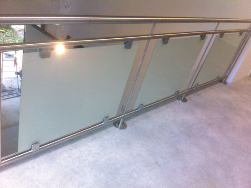 Ein Balkon mit Edelstahlgeländer und Glaspaneelen