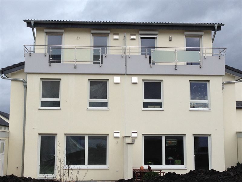 Ein Haus mit Balkon und vielen Fenstern