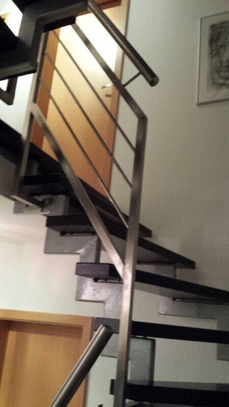 Eine Treppe mit Edelstahlgeländer und Holzstufen