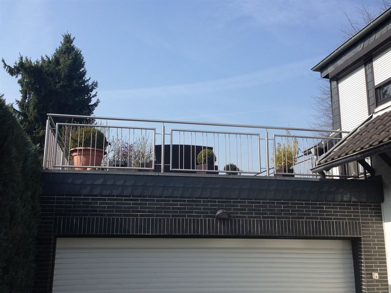 Ein Balkon über einer Garage mit Topfpflanzen darauf
