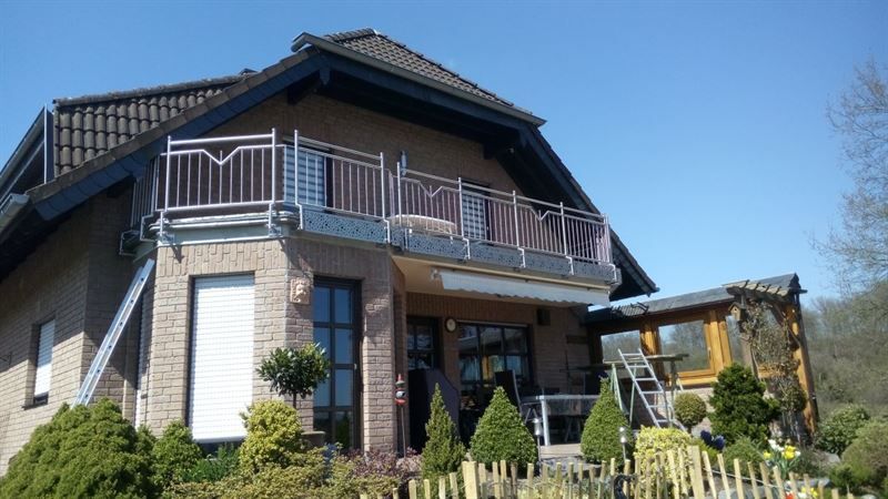Ein großes Backsteinhaus mit Balkon und Treppe