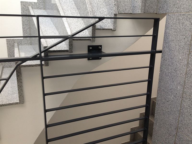 Eine Treppe mit einem Metallgeländer und einer weißen Wand