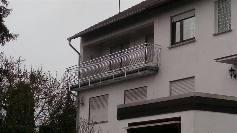 Ein weißes Haus mit einem Balkon im zweiten Stock