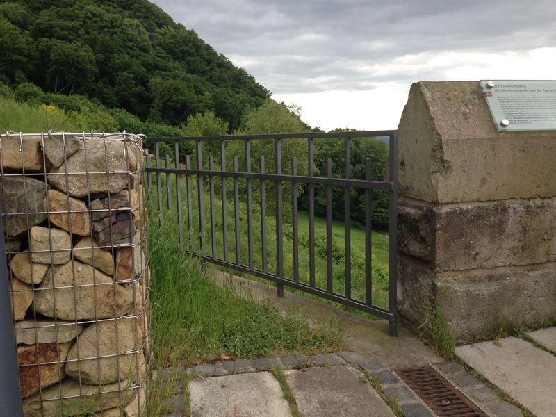Eine Steinmauer, die von einem Metallzaun umgeben ist