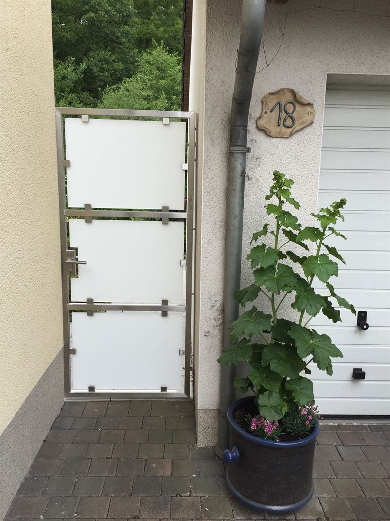 Eine Topfpflanze steht vor einem Garagentor mit der Nummer 28 darauf